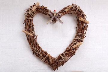 Wicker dried heart on white wall background