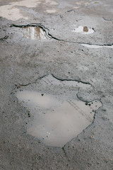 Very bad quality road with potholes and puddles
