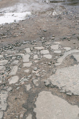 Very bad quality road with potholes and puddles
