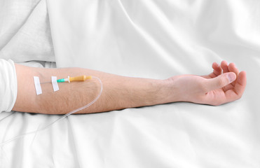 Man hand with dropper needle on bed close-up
