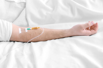 Man hand with dropper needle on bed close-up