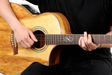 Fototapeta na wymiar Young man playing on acoustic guitar close up