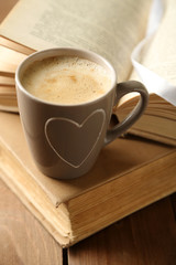 Still life with cup of coffee and books, on wooden table