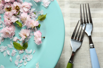 Tableware with flowers on table close up