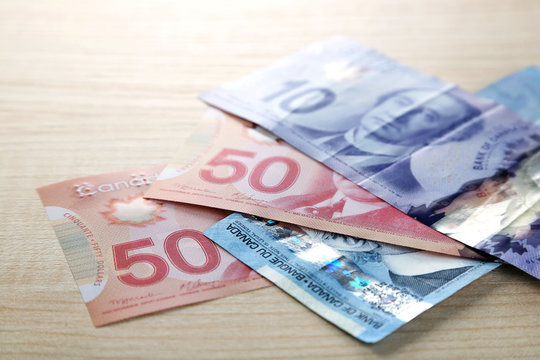 Canadian dollars on wooden table
