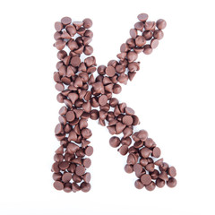 Alphabet from chocolate chips on white background