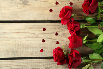 Naklejka na ściany i meble Beautiful red roses on old wooden table