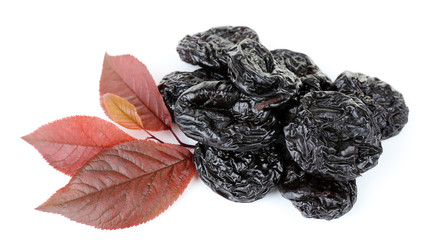 Pile of prunes with leaves isolated on white
