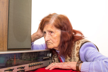 Elderly lady listening to the radio.