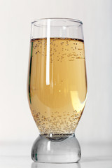 Glass of water with bubbles on table close up