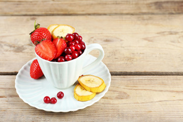 Cup of dessert with fresh fruits on wooden table, closeup