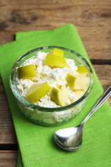 Cottage cheese with green apple on wooden table, closeup