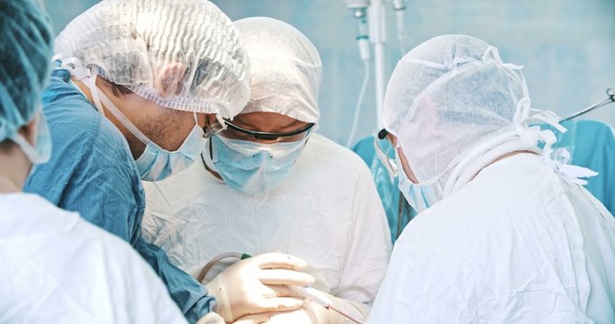 Team of surgeon in uniform perform operation