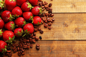 Fresh strawberry with coffee beans on wooden background