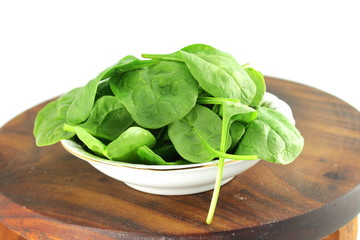 spinach leaves on wooden board in white background