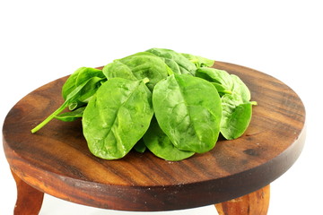 spinach leaves on wooden board in white background 