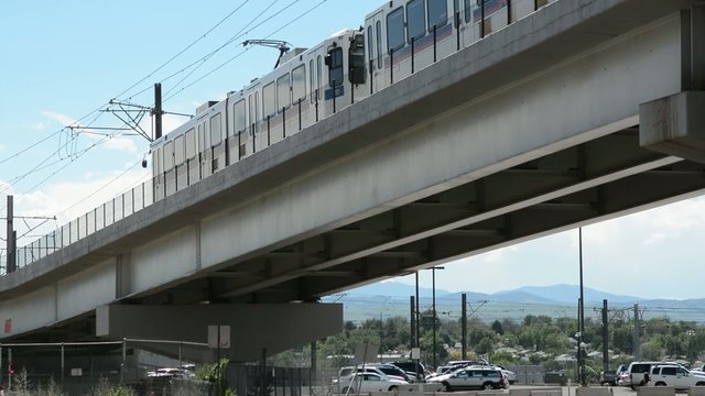 A commuter train passing by on an overpass
