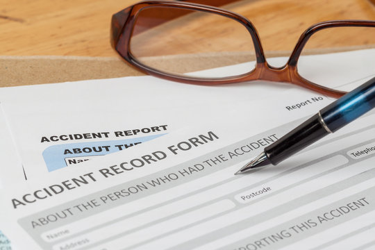Accident report application form and pen on brown envelope and e
