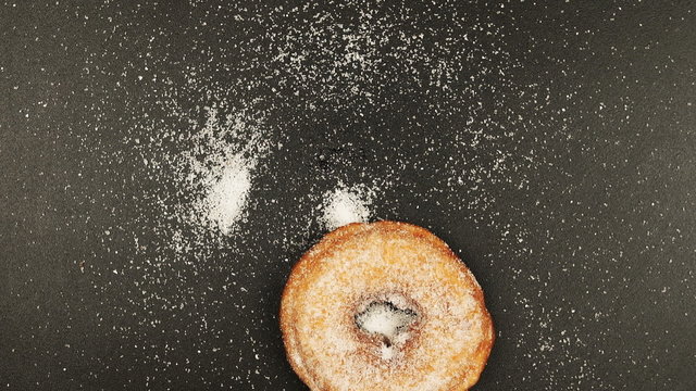 Doughnut falling on black desk
