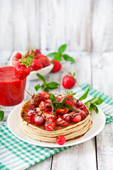 Pancakes with berries and strawberry smoothie in a rustic style