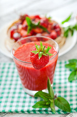 Pancakes with berries and strawberry smoothie in a rustic style