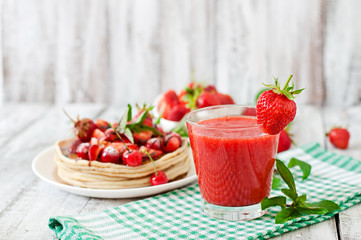 Pancakes with berries and strawberry smoothie in a rustic style