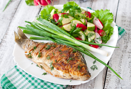 Fried fish carp and fresh vegetable salad