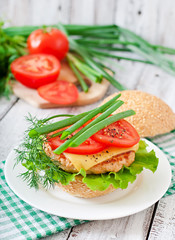 Sandwich with chicken burger, tomatoes, cheese and lettuce