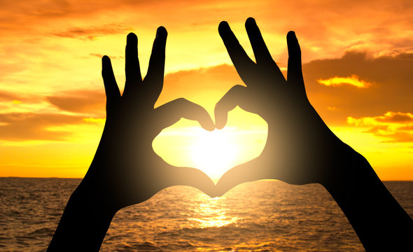 Silhouette Hand In Heart Shape On Sunset Over The Sea