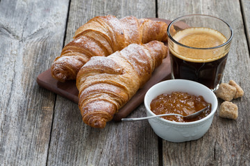 croissants, espresso and orange jamon wooden table, horizontal