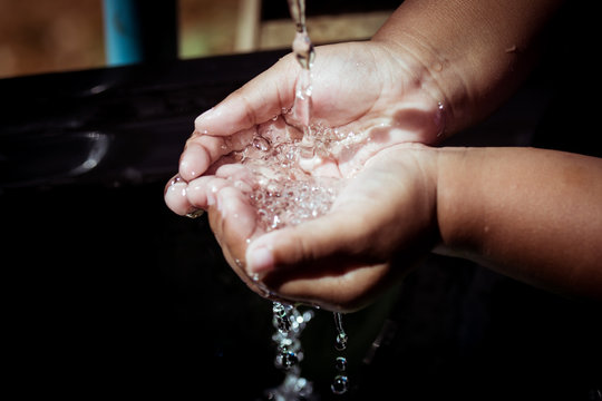 Washing of child hands under running water