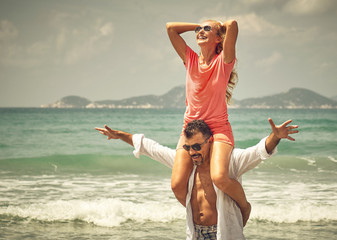 Romantic happy man giving a piggyback ride to a laughing woman