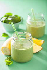 healthy green smoothie with spinach mango banana in glass jars