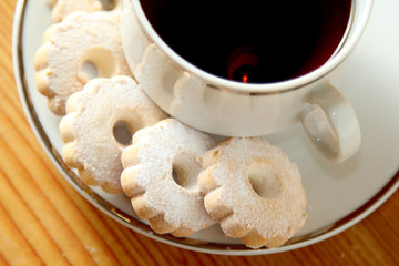 Italian Canestrelli cookies on the saucer of a cup of black tea