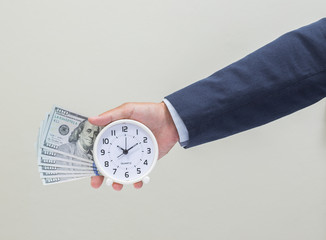 Businessman hand holding clock and money