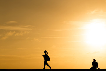Silhouette people walking at sunset