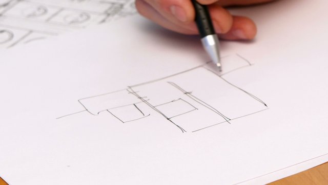 Person's Hand Drawing Plan On Blue Print. Close-up