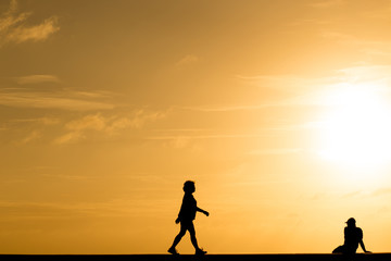 Silhouette people walking at sunset