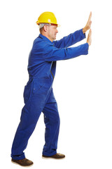 Buarbeiter schiebt imaginäre Wand zur Seite