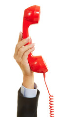 Hand hält rotes Telefon für Notruf