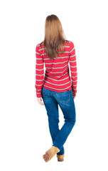 back view of standing young beautiful  blonde woman in jeans.