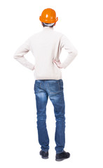Backview of an engineer in construction helmet stands. Standing