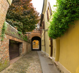 Small ancient street in the old downtown of Ferrara, Italy