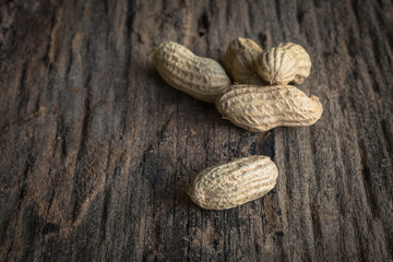 peanuts in shells on wood background