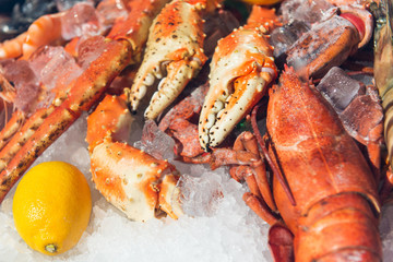 fresh frozen lobster on ice with lemon at market