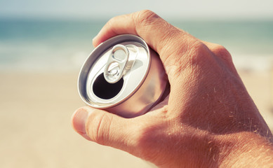 Aluminum can of beer in male hand, retro toned