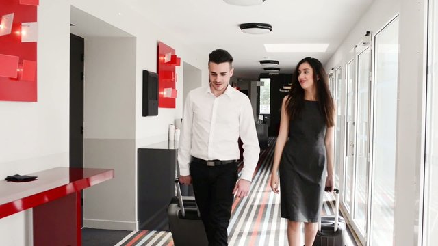 two young business person man and woman walking in public space corridor