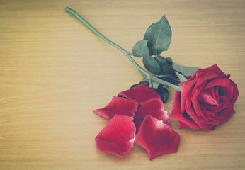 Red roses on wooden  table -  vintage (retro) style color effect