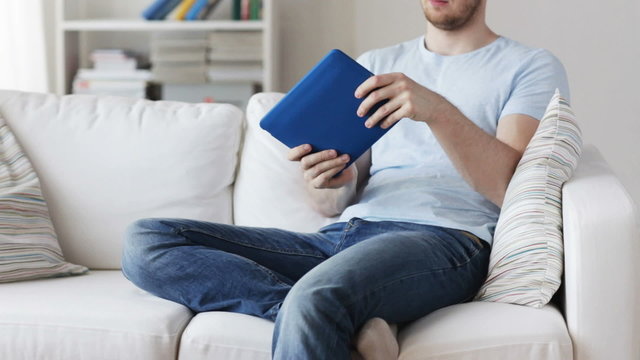 close up of man playing game on tablet pc at home