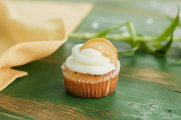 Lemon cupcake on green wooden background